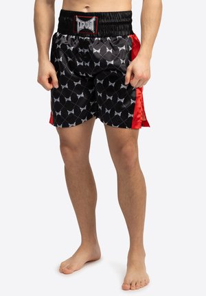 Sorte satinshorts med røde sidedele, der har et all-over mønster af hvide "TAPOUT" logoer og en elastisk talje for komfort.