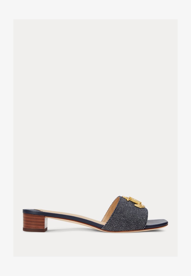 Jūras zila slaida čīpa ar teksturētu auduma augšdaļu, dekorēta ar zelta akcentu un vidēju bloku papēdi, izceļot gludu ādas iekšpusi.