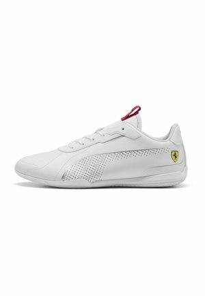 Chaussure de sport blanche avec un design perforé, des accents rouges et un logo sur le côté. Tige en cuir lisse et semelle en caoutchouc texturée.