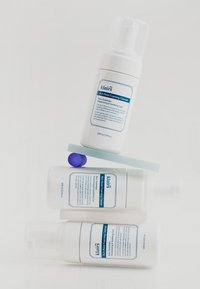 Nettoyant moussant riche en hydratation Klairs dans des flacons à pompe blancs avec des étiquettes bleues, empilés avec une carte vert menthe et un accent violet. 100 ml chacun.