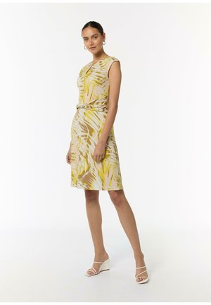 Ärmelloses Kleid in Beige mit einem gelben und braunen tropischen Blättermuster. Es hat eine taillierte Taille und eine leicht ausgestellte Silhouette.
