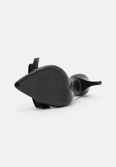 Sorte højhælede sko med spids tå-design, glat patentfinish og elastiske remme bagpå for et sikkert fit.