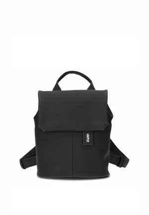 Small black backpack with flap closure, top carry handle, adjustable shoulder straps, and a visible brand tag on the front.