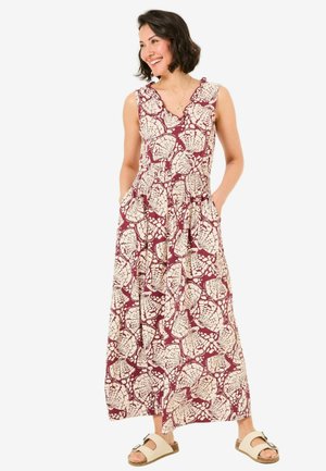 Langes bordeauxrotes Maxikleid mit einem weißen Blättermuster, V-Ausschnitt, Rüschenträgern und Taschen. Getragen mit beigen Sandalen.