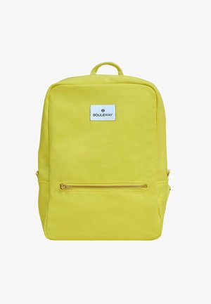 Gul rygsæk lavet af stof med en rektangulær form. Har en frontlynlås lomme, bærehåndtag på toppen og et mærke på forsiden.