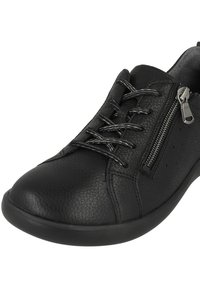 Baskets en cuir noir avec surface texturée, dotées de lacets et d'une fermeture éclair sur le côté. Bout arrondi et semelle en caoutchouc. Subtiles perforations sur le côté.