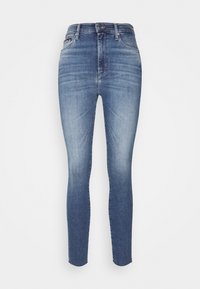 Jeans ajustados en denim azul claro con una textura suave. Presentan una cintura estándar, diseño de cinco bolsillos y un ligero desvanecimiento cerca de las rodillas.