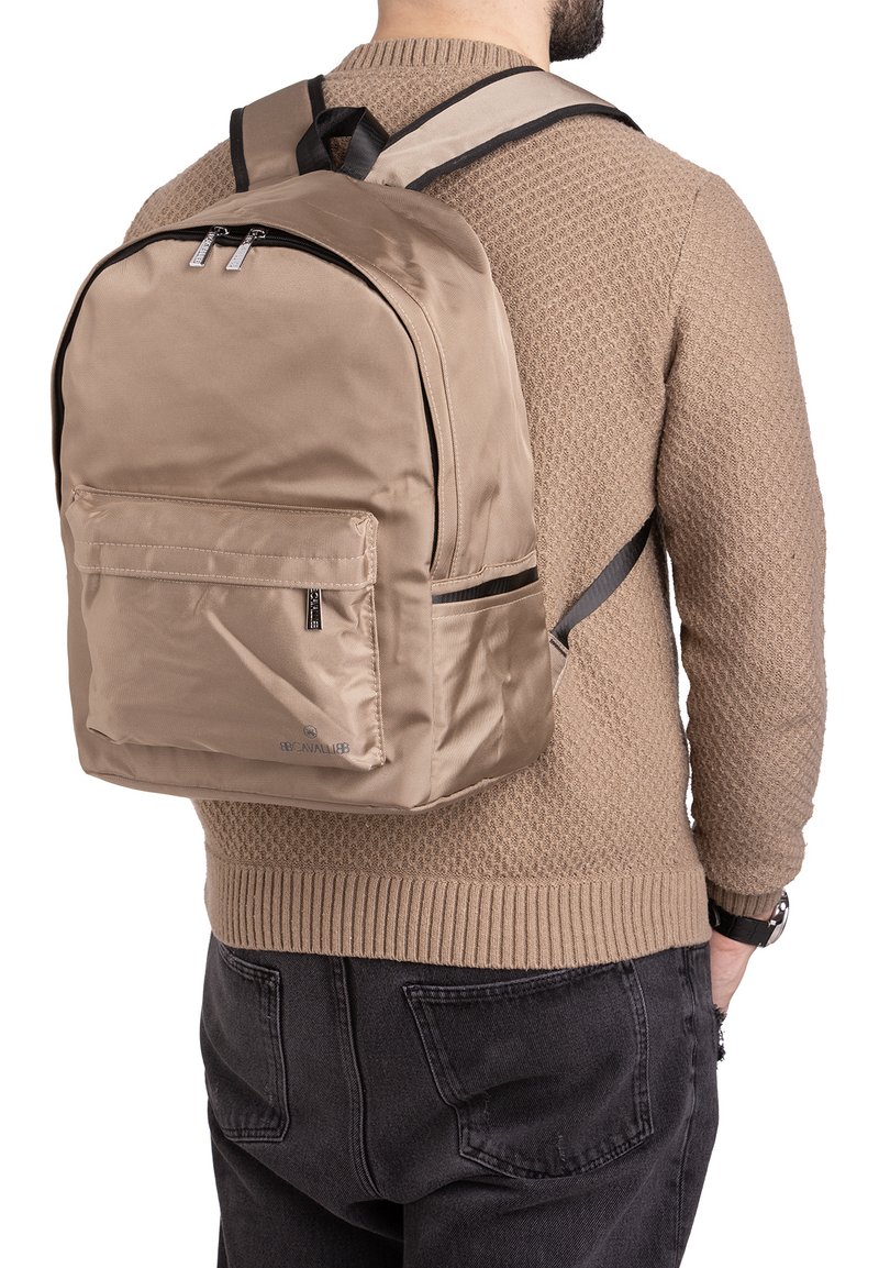 Sac à dos en nylon beige avec des bretelles réglables, deux compartiments zippés et une poche avant ; texture lisse et élégante, design minimaliste.