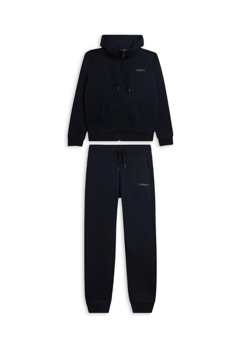 Conjunto de dos piezas de ropa deportiva en azul marino que incluye una chaqueta con capucha y cierre de cremallera y pantalones a juego, ambos con una textura suave y bolsillos delanteros.