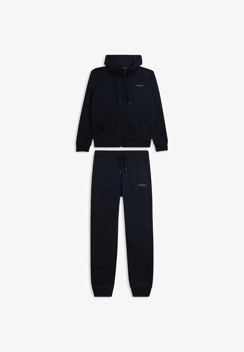 Conjunto de dos piezas de ropa deportiva en azul marino que incluye una chaqueta con capucha y cierre de cremallera y pantalones a juego, ambos con una textura suave y bolsillos delanteros.