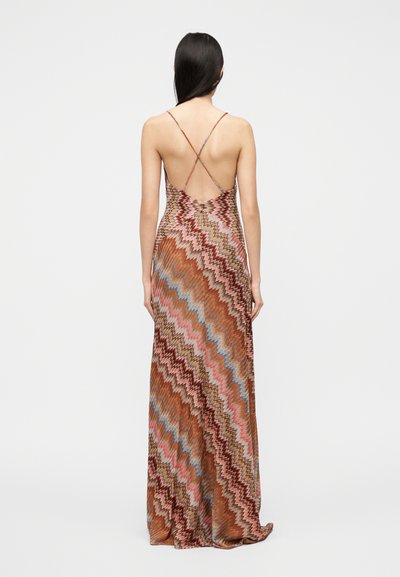 Μάξι φόρεμα με ζιγκ ζαγκ μοτίβο σε γήινους τόνους καφέ, ροζ και μπλε. Διαθέτει λεπτές σταυρωτές τιράντες και ανοιχτή πλάτη.