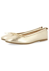 Bailarinas metálicas doradas con punta afilada, que presentan un delicado lazo decorativo y una textura suave, sobre una suela plana en tono marrón.