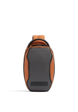 Compact sling backpack with black front panel and brown sides, top handle, and zipper closure.