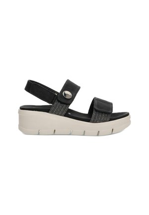 Sandalias negras con una correa texturizada, hebilla ajustable y una suela de plataforma ligera en color beige. Presentan un detalle trenzado en la parte superior.