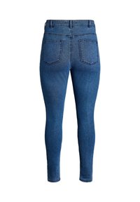 Jeans de denim azul ajustados con una textura suave, que cuentan con dos bolsillos traseros y detalles de costura, estrechándose en los tobillos.