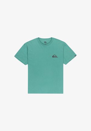 Teal puuvillapaita, jossa on lyhyet hihat ja pyöreä kaula-aukko. Vasemman rinnan alueella on pieni tummanharmaa logo. Yksinkertainen muotoilu.