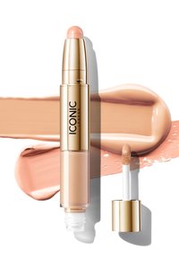 Iluminador líquido en un tubo metálico dorado con un aplicador redondeado de tono rosa. Acompañado por una muestra cremosa de producto en color beige.