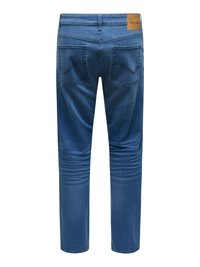 Jeans in denim blu mostrati da dietro con due tasche posteriori e un'etichetta marrone in pelle del marchio sulla vita.