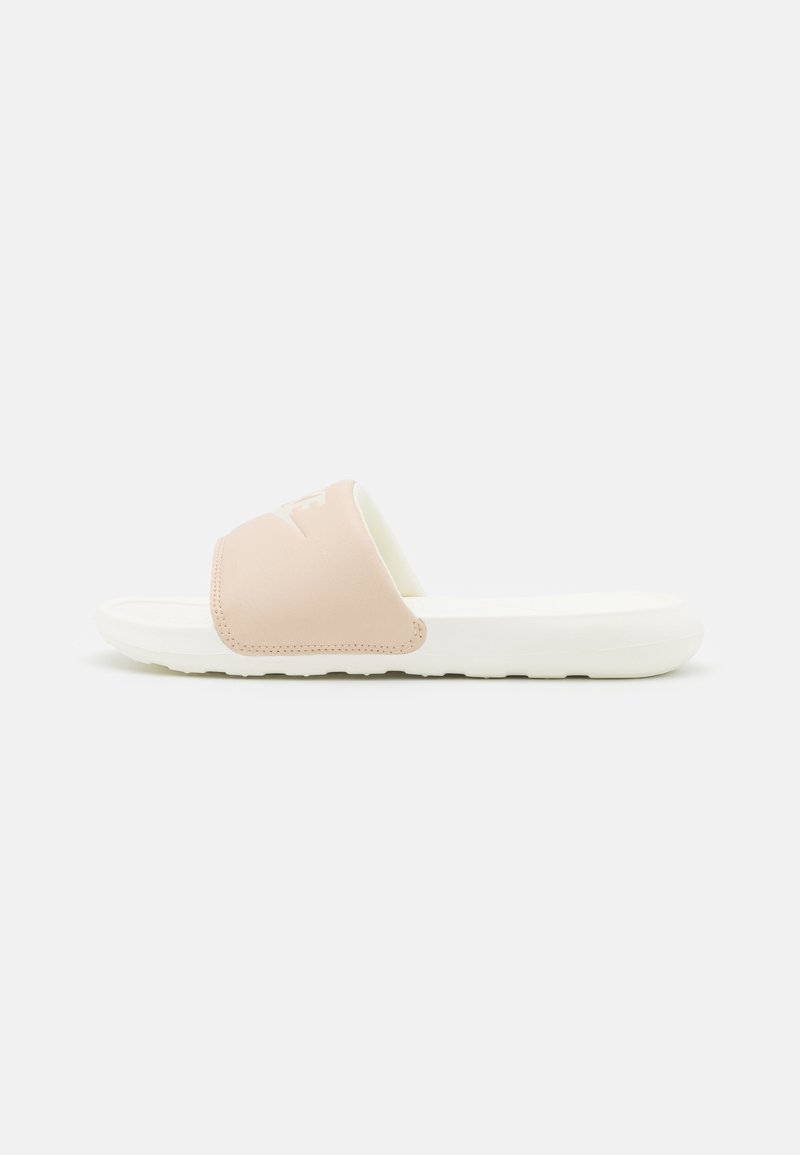 Sandale à glissière rose clair avec une lanière supérieure lisse et une semelle en caoutchouc blanche, présentant un design minimaliste sans motifs ni accents visibles.