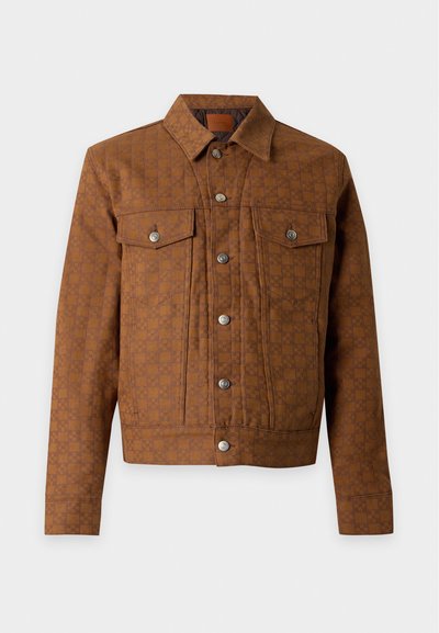 Veste marron à carreaux avec boutons, deux poches poitrine et boutons argentés, présentée sur un fond clair uni.