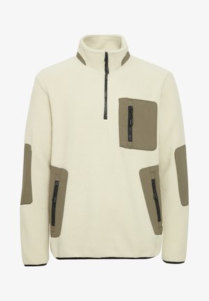 Fleecetröja i off-white med olivgröna detaljer. Har en halv dragkedja, bröstficka och fickor på sidan med dragkedja. Texturerad tyg.