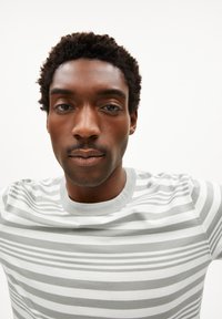 Grijs-wit gestreept T-shirt met een ronde hals en korte mouwen, gemaakt van zachte stof, met horizontale lijnen van verschillende breedtes.