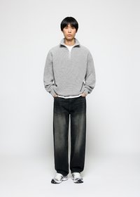 Grå strikket halv-zip genser, avslappet passform, kombinert med mørk vask straight-leg jeans og sporty grå og sølv sneakers.