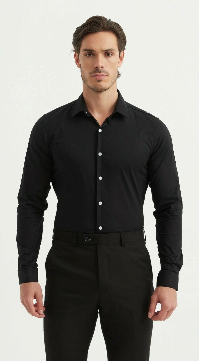 Chemise noire à manches longues avec col à boutons, boutons blancs et finition en tissu lisse. Portée avec un pantalon noir, bien rentré.