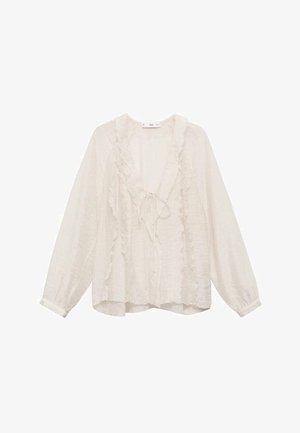 Bluză albă cu mâneci lungi, confecționată dintr-un material ușor, având accentefranjuri de-a lungul gâtului în V și pe față, cu o croială lejeră.