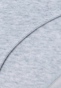 Light grey soft fabric with visible stitching and curved seam detail, showing texture and knit pattern close-up.
