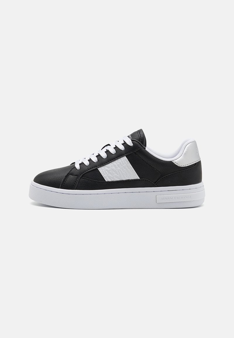 Must musta sneaker sisaldab tekstureeritud valget külge, valgeid paelu ja valget väliskesta. Bränd on nähtav kandmisel.