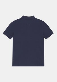 Tmavě modré polo tričko s krátkým rukávem, proužkovaným límečkem a hladkým povrchem. Jednoduchý design bez vzorů nebo viditelných akcentů. Zadní pohled.