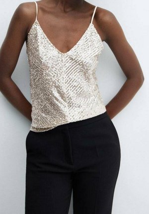Beige pailletten top met een V-hals en spaghettibandjes, gecombineerd met zwarte taillepanten. Beschikt over een geometrisch paillettenpatroon.