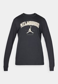 Fekete hosszú ujjú póló, amelyen egy krémszínű grafika található, amelyen az "MILWAUKEE" felirat olvasható, alatta pedig egy jumpman sziluett látható. Puha pamut anyag.