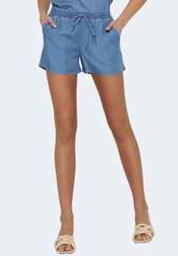 Shorts de mezclilla con cintura elástica y cordón, con bolsillos laterales y un corte relajado. Color azul claro con una textura suave.