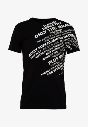 Zwart katoenen T-shirt met gedurfde witte tekst in verschillende lettertypen en oriëntaties, inclusief merknamen en waarschuwingen. Korte mouwen, ronde hals.