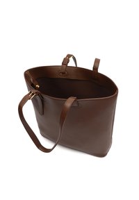 Braune Leder-Tragetasche mit zwei Trägern und goldenen Schnallendetails, auf weißem Hintergrund offen und leer gezeigt.