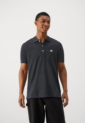 Tamsiai pilkas polo marškinėliai, pagaminti iš medvilnės, su apykakle, trimis mygtukais ir išsiuvinėtu logo kairėje krūtinės pusėje. Trumpomis rankovėmis.