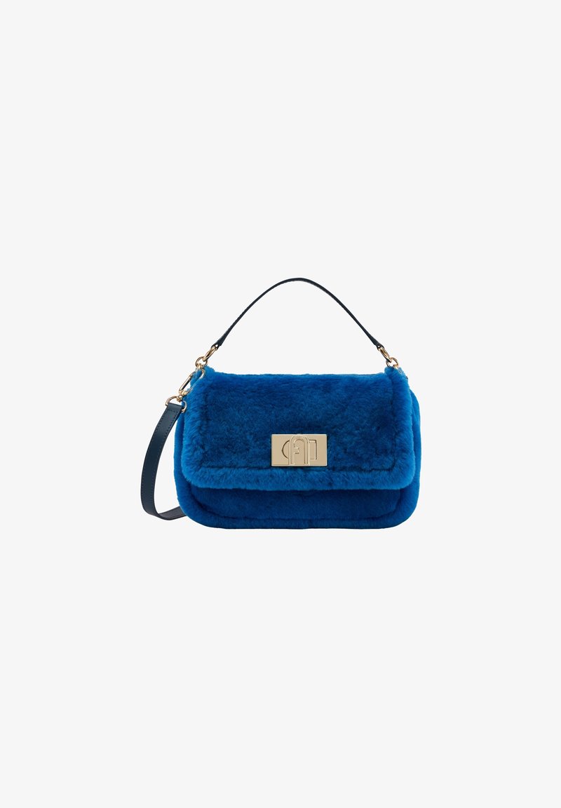 Sac à main en fausse fourrure bleue avec fermoir rectangulaire doré, poignée courte et bandoulière amovible sur fond blanc.