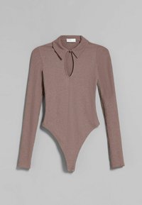 Långärmad bodysuit i ribbad tyg, ljusbrun färg. Utrustad med krage, nyckelhålsringning och tryckknappslås i botten.