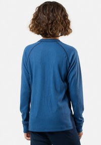 Camicia a maniche lunghe in un profondo materiale a coste blu, presenta un collo rotondo e cuciture a contrasto lungo le spalle.