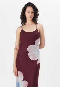 Vestido bordeaux com alças finas, apresentando grandes padrões de flores brancas em rosa e azul claro. Tecido suave com um design ajustado.