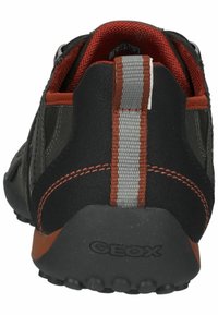 Scarpa casual nera e grigio scuro con fodera interna rossa, linguetta riflettente verticale, cuciture arancioni e suola in gomma con marchio GEOX.