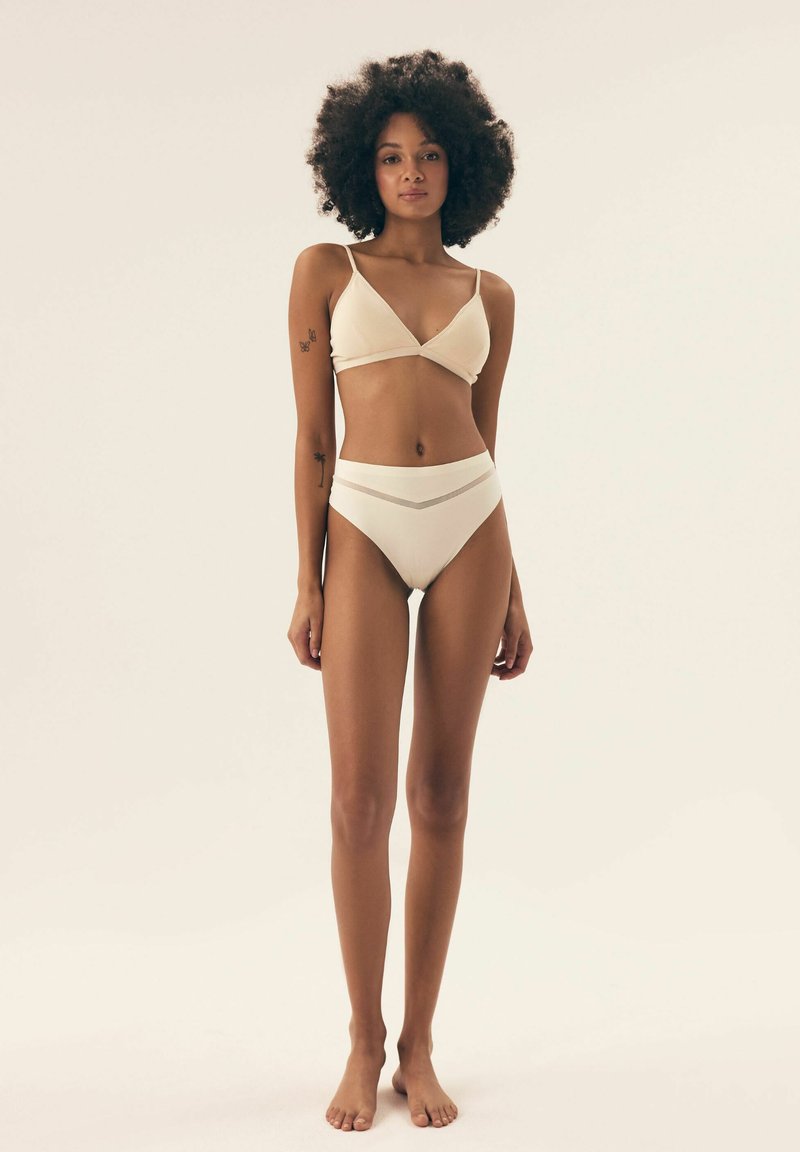 Weißes, geripptes Bikini-Oberteil mit verstellbaren Trägern und dazu passendem hochgeschnittenem Höschen mit einem strukturierten Bund. Glattes Material und minimalistisches Design.