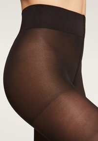 Svarta genomskinliga strumpbyxor med en strukturerad, bred midjeband. Tyget är slätt och semi-transparent, vilket ger en åtsittande look.