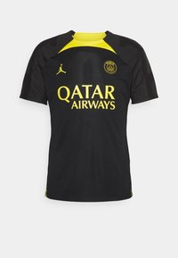 Camiseta deportiva negra con detalles en amarillo. Cuenta con cuello redondo, mangas cortas y un logo en el pecho. Fabricada con material ligero.