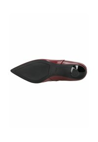 Zapato de tacón rojo de piel con punta afilada y un diseño elegante, que cuenta con una suela negra texturizada y un acento brillante en el tacón.