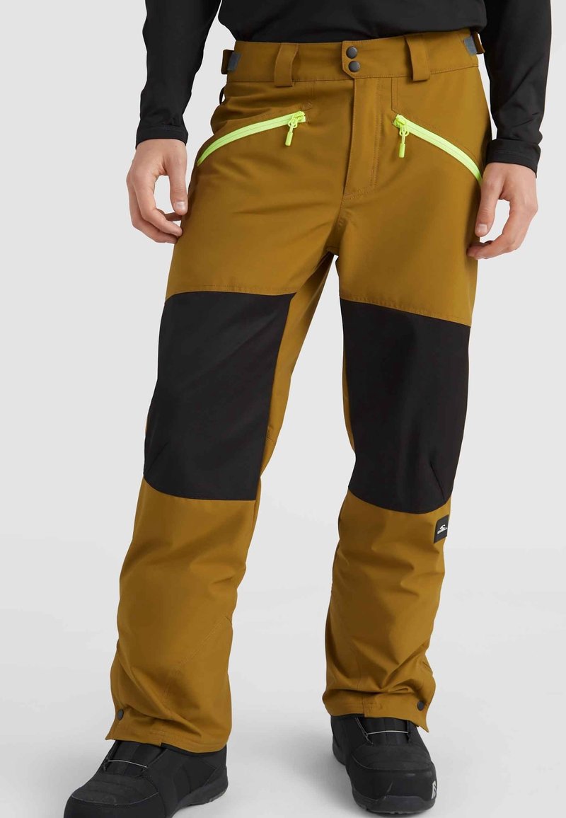 Pantalon de ski marron et noir avec poches zippées, panneaux contrastants et poignets réglables. Fabriqué en matériau synthétique et imperméable.