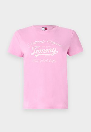T-shirt en coton rose avec col rond, manches courtes, et texte blanc : "Authentic Original, Tommy, est. 1985, New York City" dans une police stylisée.