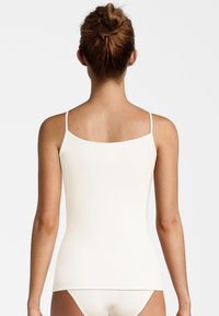 White sleeveless tank top with thin straps, fitted design, smooth texture, and a clean silhouette, viewed from the back.
